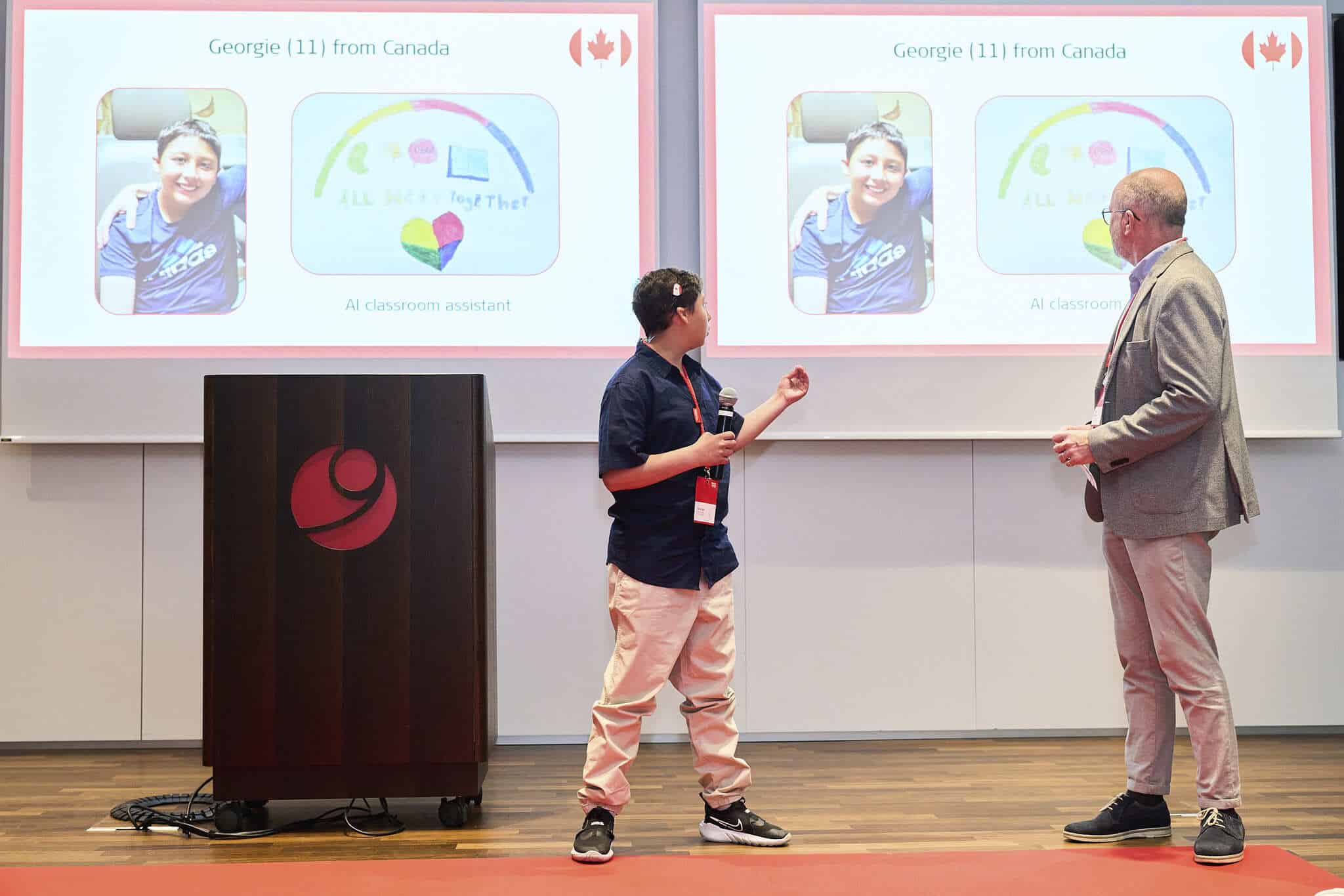 Georgie presenting his ALLHearTogether invention alongside Dr. Patrick D'Haese, Corporate Director of Awareness and Public Affairs at MED-EL
